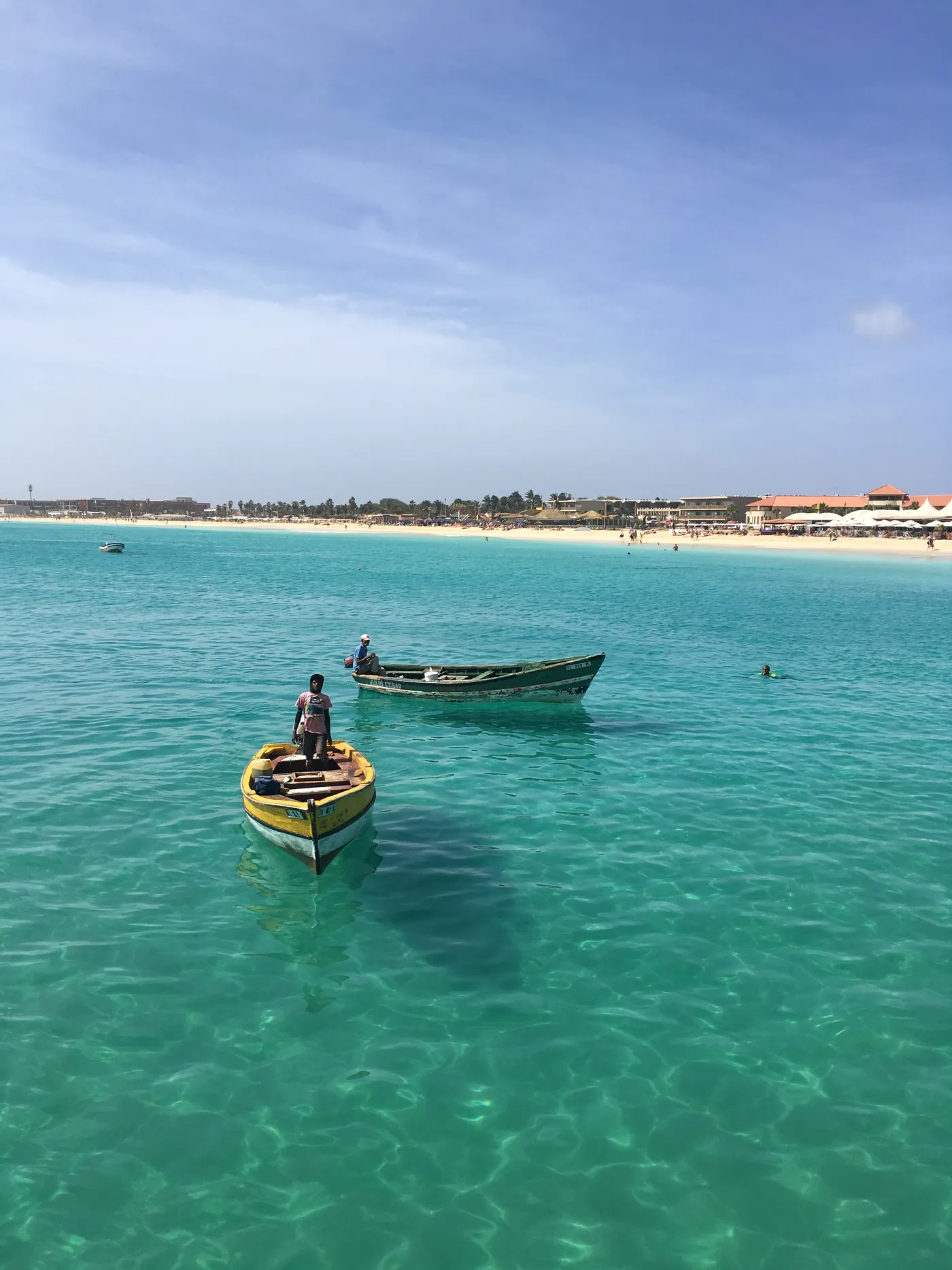 Barcos de pesca nas águas turquesa junto à praia de Santa Maria, na Ilha do Sal