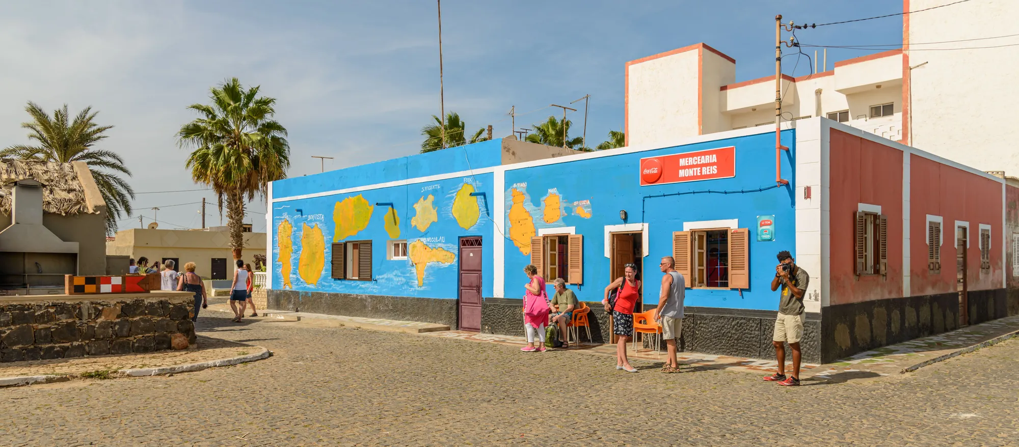 Casa azul e colorida numa rua da Ilha do Sal, com palmeiras
